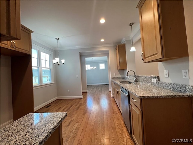 kitchen with sink, dishwasher, dark stone countertops, a notable chandelier, and a wealth of natural light