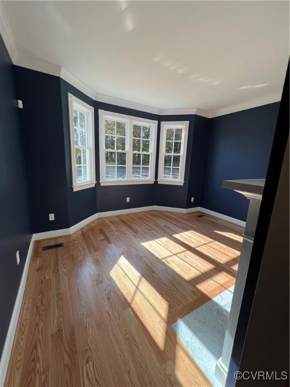 unfurnished room featuring ornamental molding and light hardwood / wood-style floors