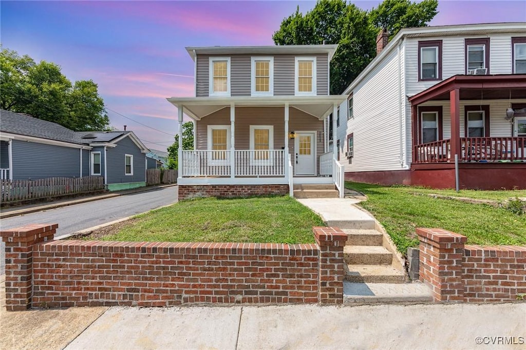 view of front of home with a porch and a lawn