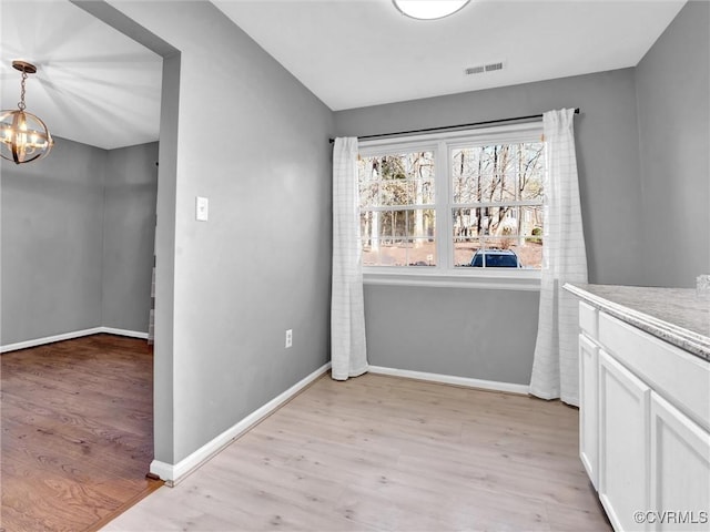 interior space with an inviting chandelier and light hardwood / wood-style flooring