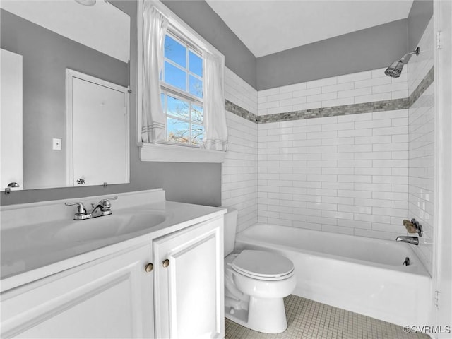 full bathroom featuring vanity, tiled shower / bath combo, tile patterned floors, and toilet