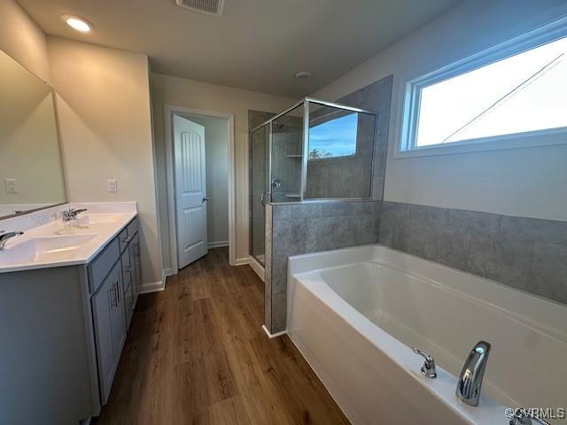 bathroom featuring vanity, hardwood / wood-style floors, and separate shower and tub