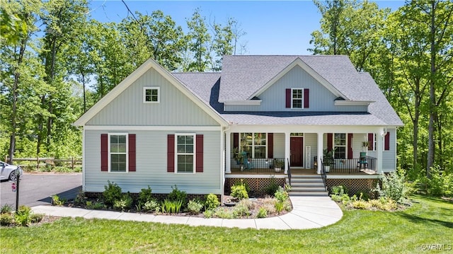 view of front facade featuring a shingled roof, a front lawn, and a porch