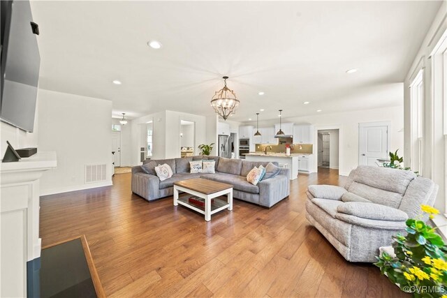 living room featuring a chandelier and light hardwood / wood-style floors