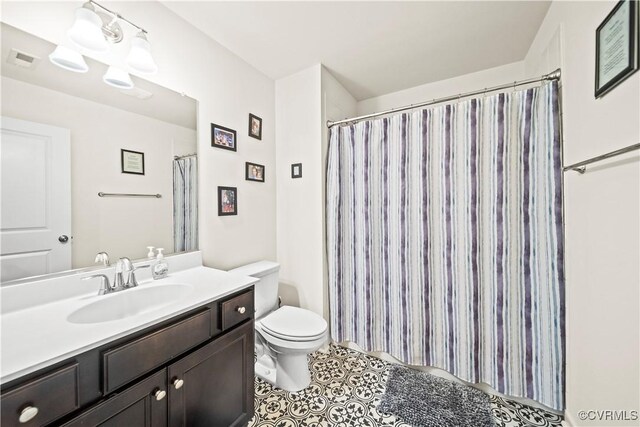 bathroom featuring tile patterned floors, vanity, and toilet