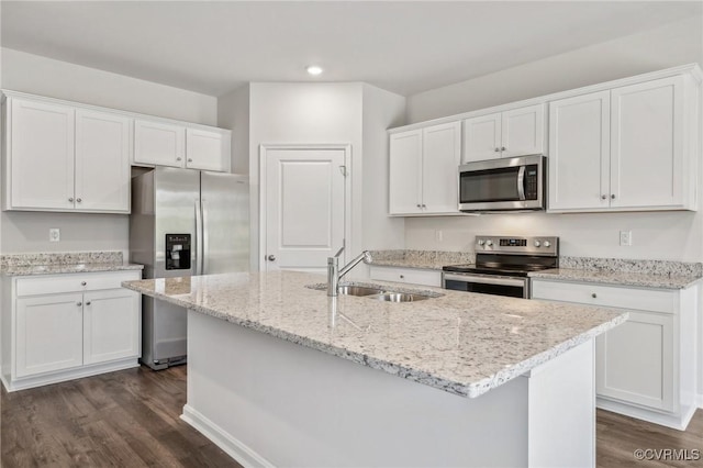 kitchen with white cabinets, appliances with stainless steel finishes, an island with sink, and sink