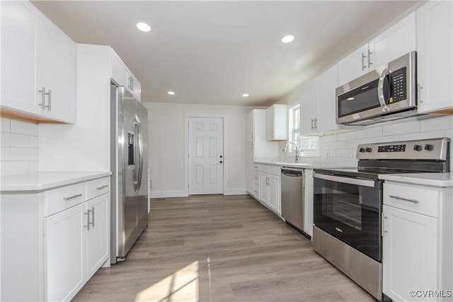 kitchen with sink, white cabinetry, and stainless steel appliances