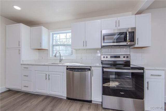 kitchen with white cabinetry, sink, and appliances with stainless steel finishes