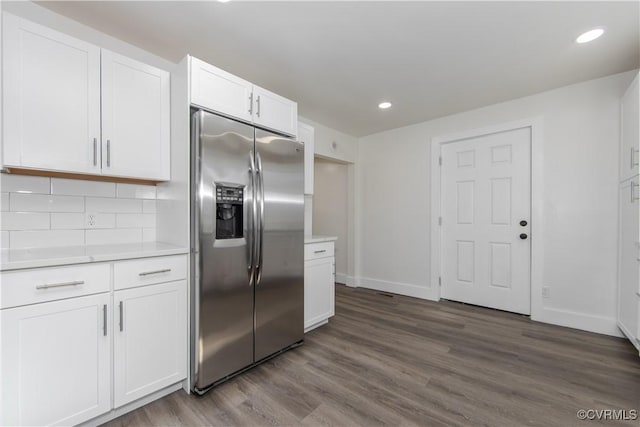 kitchen with stainless steel refrigerator with ice dispenser, tasteful backsplash, white cabinetry, and wood-type flooring