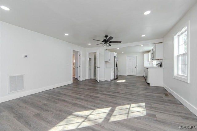 unfurnished living room with hardwood / wood-style flooring and ceiling fan