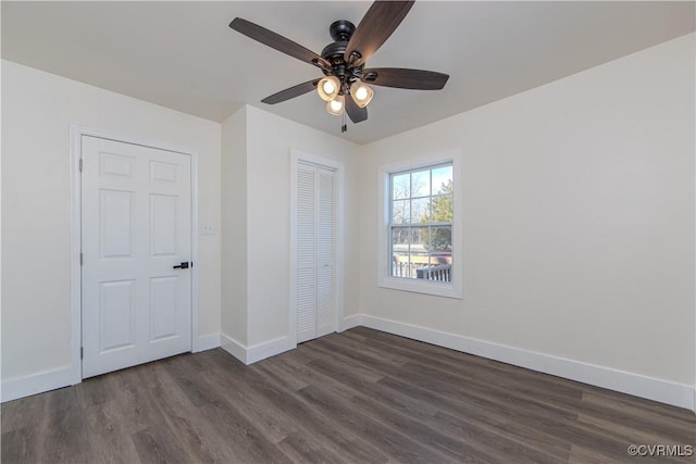 unfurnished bedroom with ceiling fan and dark wood-type flooring