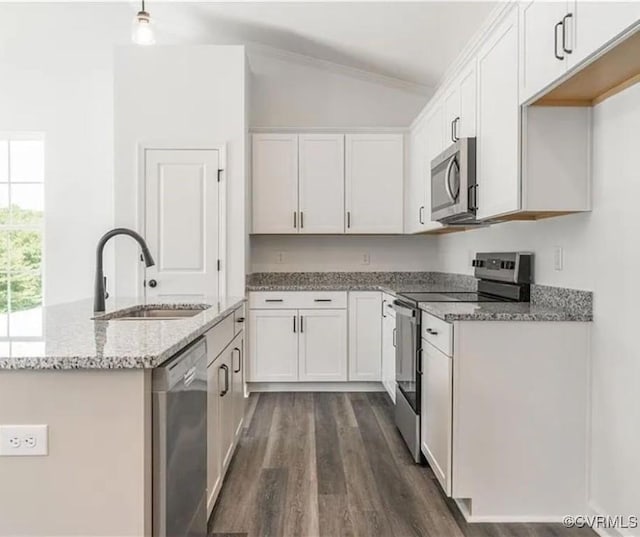 kitchen with light stone counters, white cabinets, appliances with stainless steel finishes, and sink