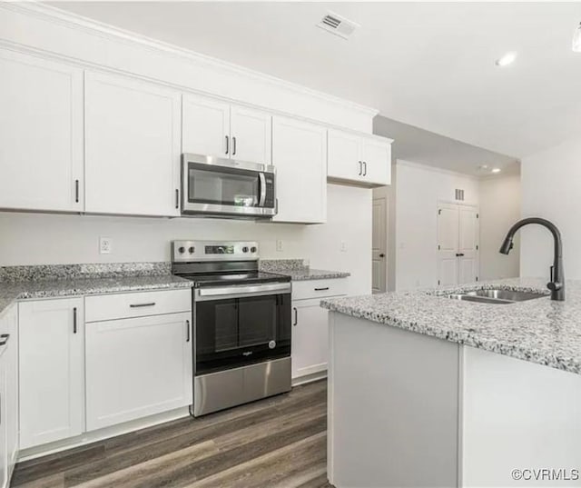 kitchen with light stone countertops, appliances with stainless steel finishes, white cabinets, and sink