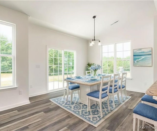 dining space with dark hardwood / wood-style flooring and a chandelier