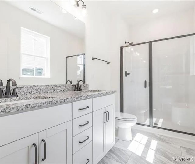 bathroom featuring toilet, vanity, and an enclosed shower