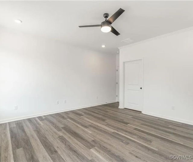 empty room with ceiling fan, dark hardwood / wood-style floors, and crown molding