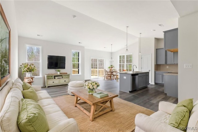 living area featuring dark wood-type flooring, visible vents, and high vaulted ceiling