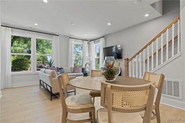 dining area with light hardwood / wood-style floors and a wealth of natural light