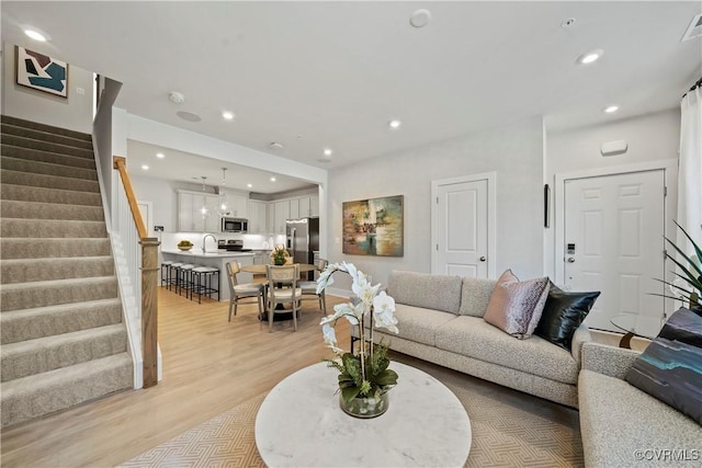 living room featuring light hardwood / wood-style flooring and sink