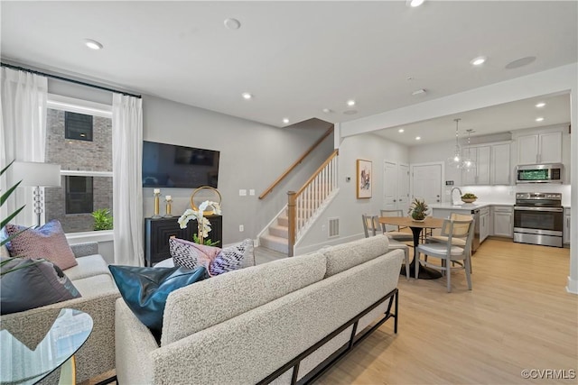 living room featuring sink, a fireplace, and light hardwood / wood-style flooring