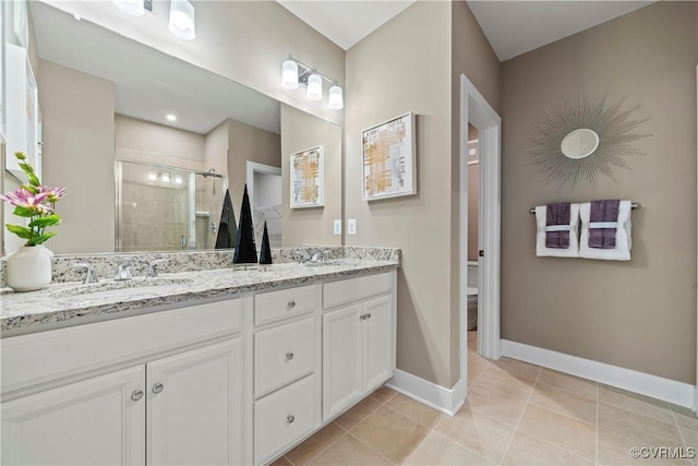 bathroom with tile patterned flooring, vanity, toilet, and a shower with door