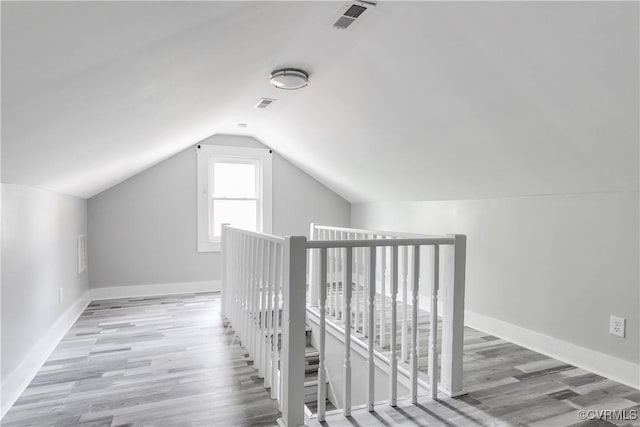 bonus room with light hardwood / wood-style flooring and vaulted ceiling