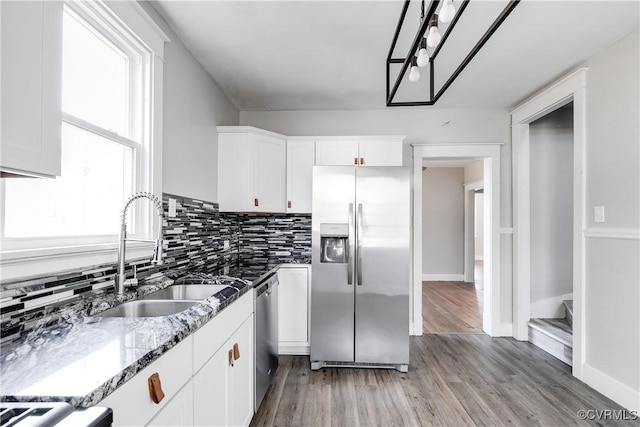 kitchen with sink, light hardwood / wood-style flooring, stone countertops, white cabinetry, and stainless steel appliances