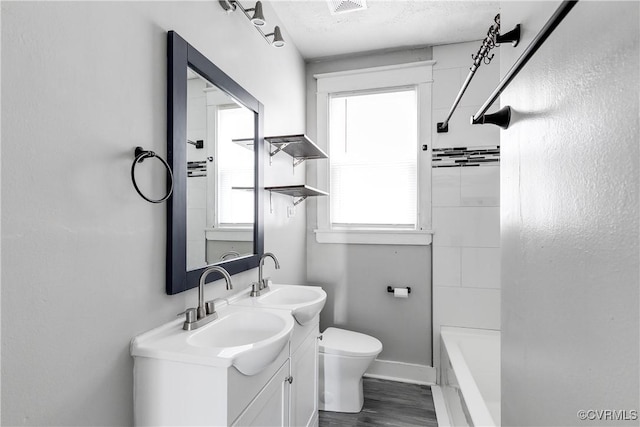 full bathroom with vanity, bathing tub / shower combination, toilet, a textured ceiling, and wood-type flooring