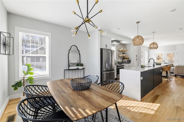 dining room featuring light wood-type flooring, a wealth of natural light, and sink