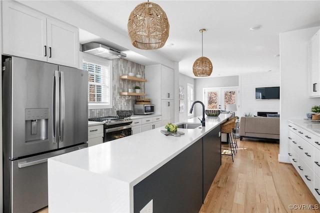 kitchen with stainless steel appliances, white cabinets, pendant lighting, and sink