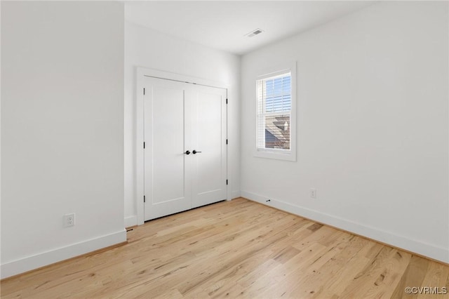 unfurnished bedroom featuring light wood-type flooring and a closet