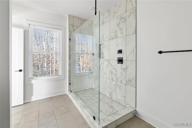 bathroom with tile patterned flooring, plenty of natural light, and a shower with shower door