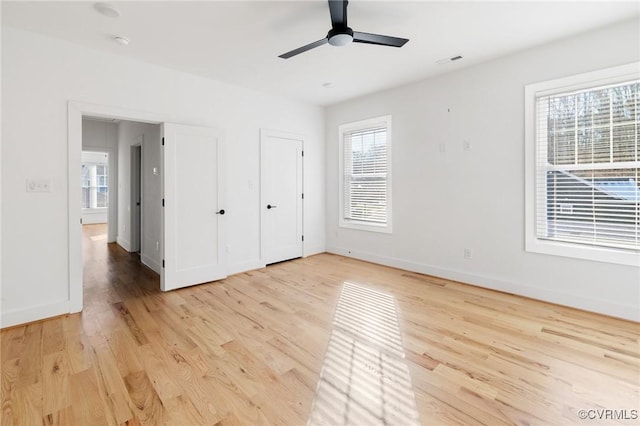 unfurnished bedroom with multiple windows, ceiling fan, and light hardwood / wood-style flooring