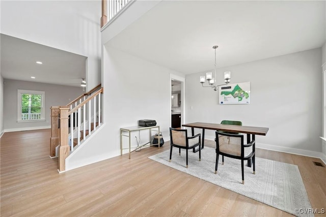 dining room featuring light wood-type flooring and an inviting chandelier