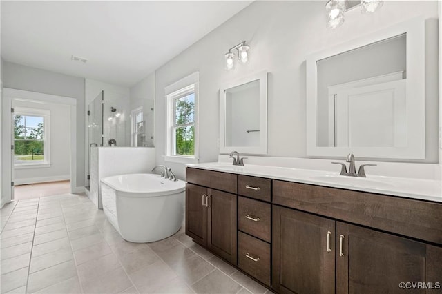 bathroom featuring tile patterned flooring, shower with separate bathtub, vanity, and plenty of natural light