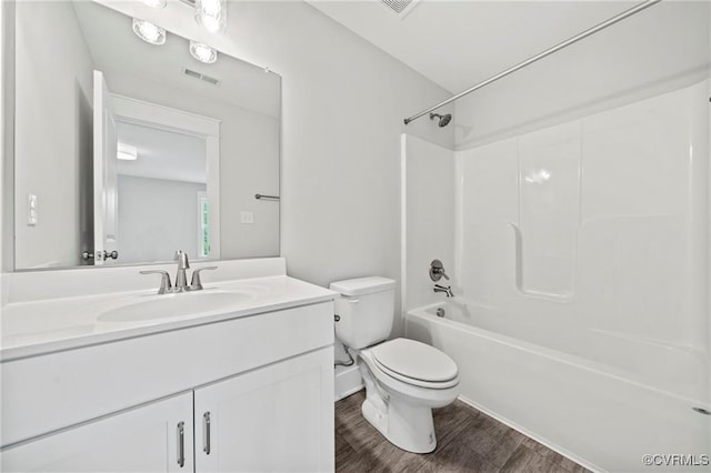 full bathroom with hardwood / wood-style flooring, vanity,  shower combination, and toilet