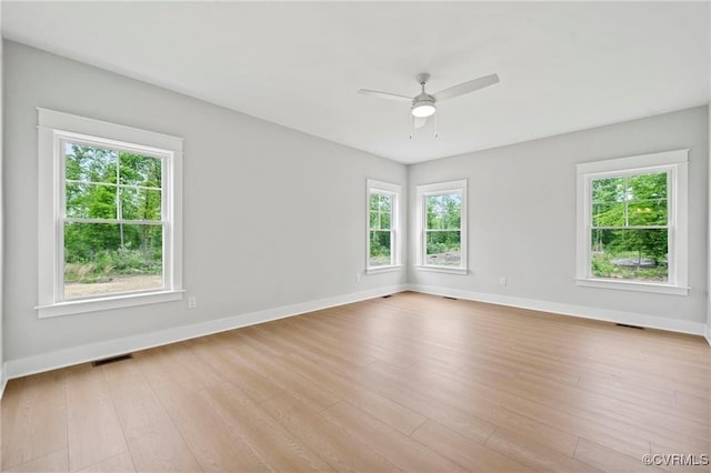 spare room with ceiling fan, a healthy amount of sunlight, and light wood-type flooring