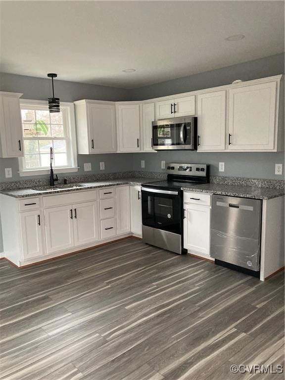 kitchen featuring sink, dark hardwood / wood-style flooring, white cabinetry, and stainless steel appliances