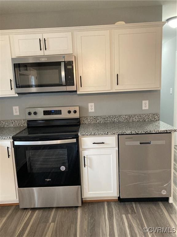 kitchen featuring white cabinets, light stone counters, and stainless steel appliances