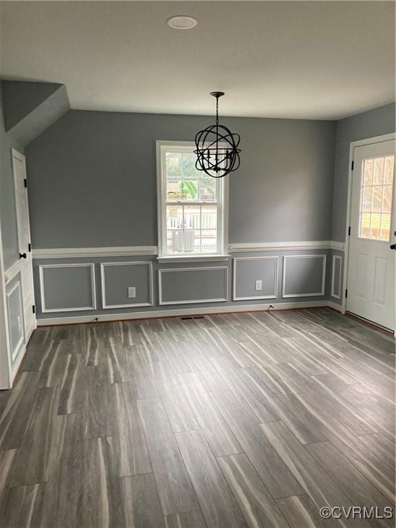 unfurnished dining area featuring hardwood / wood-style flooring and a notable chandelier