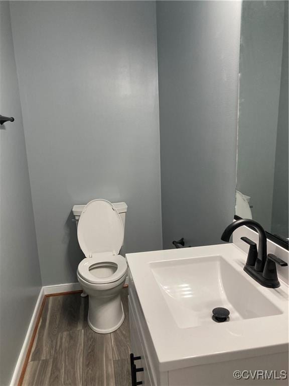 bathroom with hardwood / wood-style flooring, vanity, and toilet