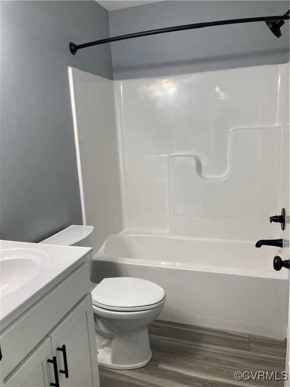 full bathroom with shower / bath combination, vanity, toilet, and wood-type flooring