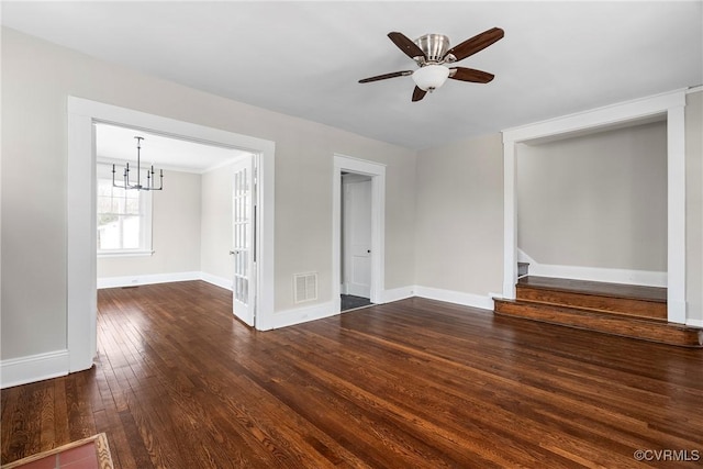 unfurnished living room featuring ceiling fan with notable chandelier and dark wood-type flooring