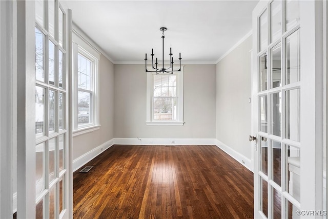 unfurnished dining area with dark wood-type flooring, crown molding, and a chandelier