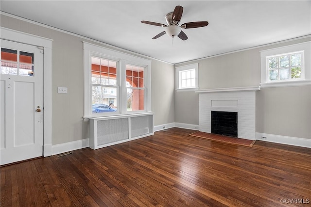 unfurnished living room with a fireplace, ceiling fan, dark hardwood / wood-style floors, and ornamental molding