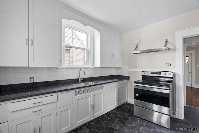 kitchen with tasteful backsplash, white cabinets, and stainless steel range with electric stovetop