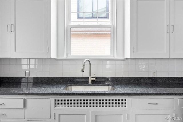 kitchen featuring tasteful backsplash, white cabinets, dishwasher, and sink