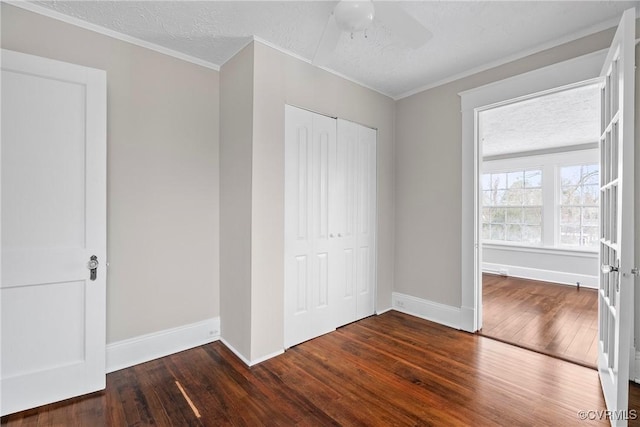 unfurnished bedroom with ceiling fan, a closet, dark hardwood / wood-style floors, and a textured ceiling