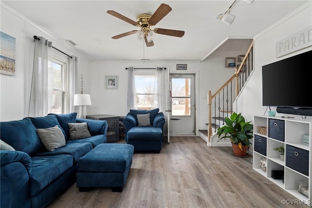 living room with rail lighting, hardwood / wood-style floors, ornamental molding, and a healthy amount of sunlight