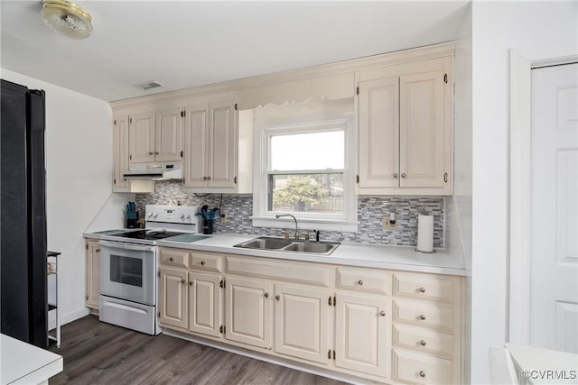 kitchen featuring decorative backsplash, sink, white electric range oven, and black refrigerator